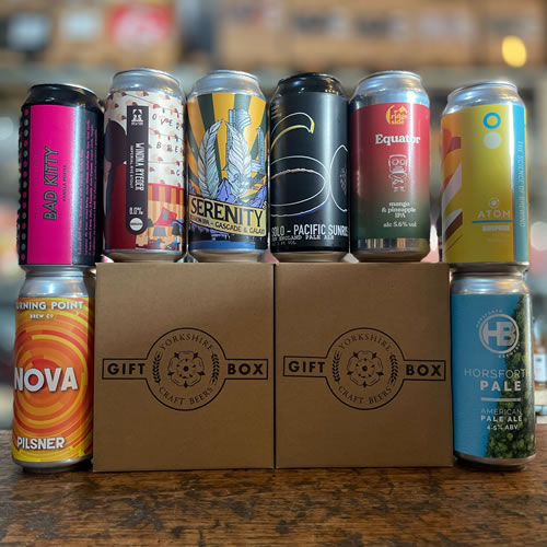 Various styles of craft beer in cans displayed on an oak table