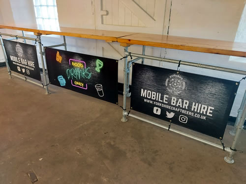 Modular popup bar made from wood and steel with banners at the front